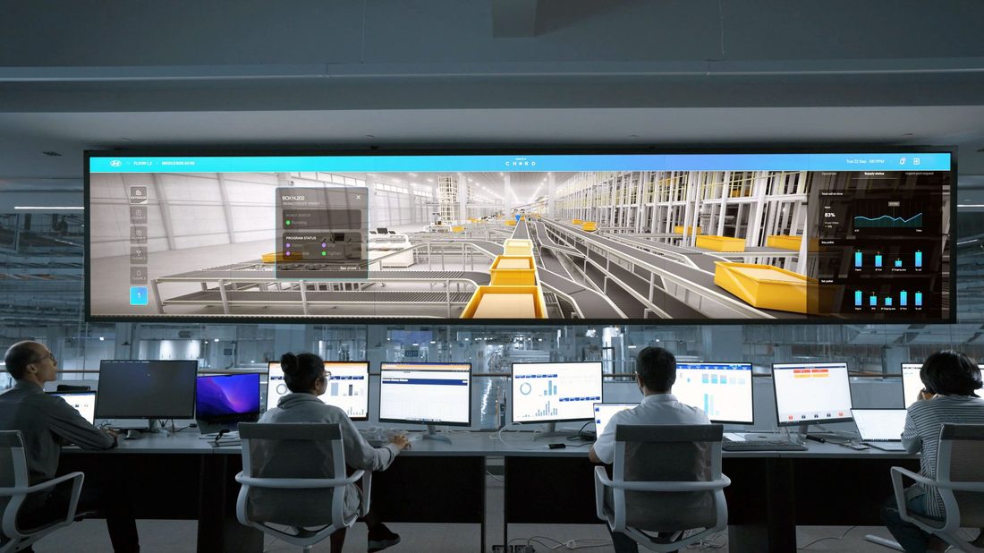 Operators in a control room facing a large display wall