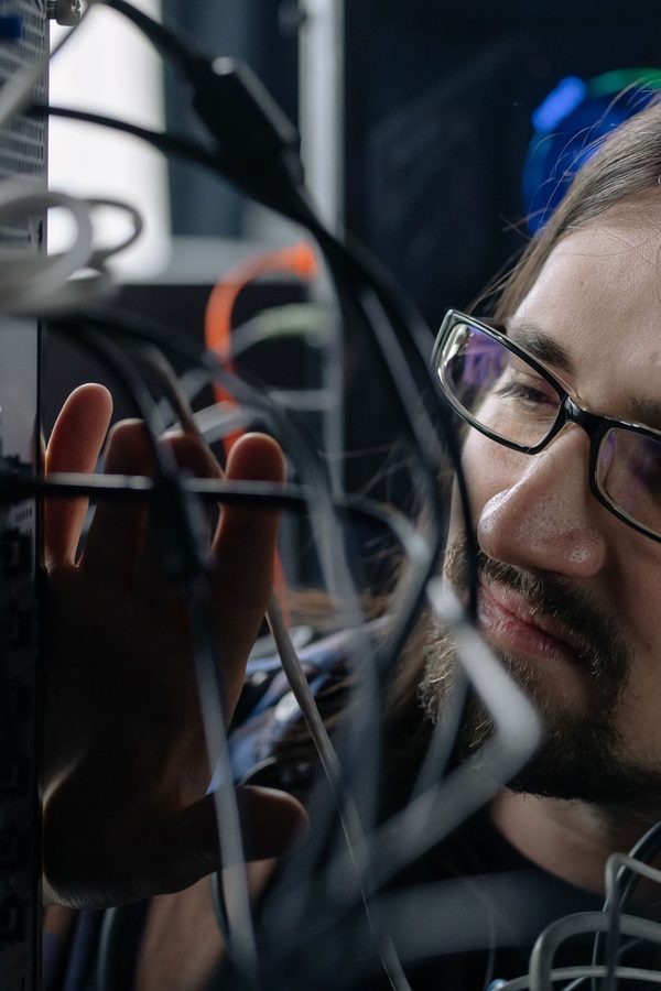 Technician handling network cables in a server room