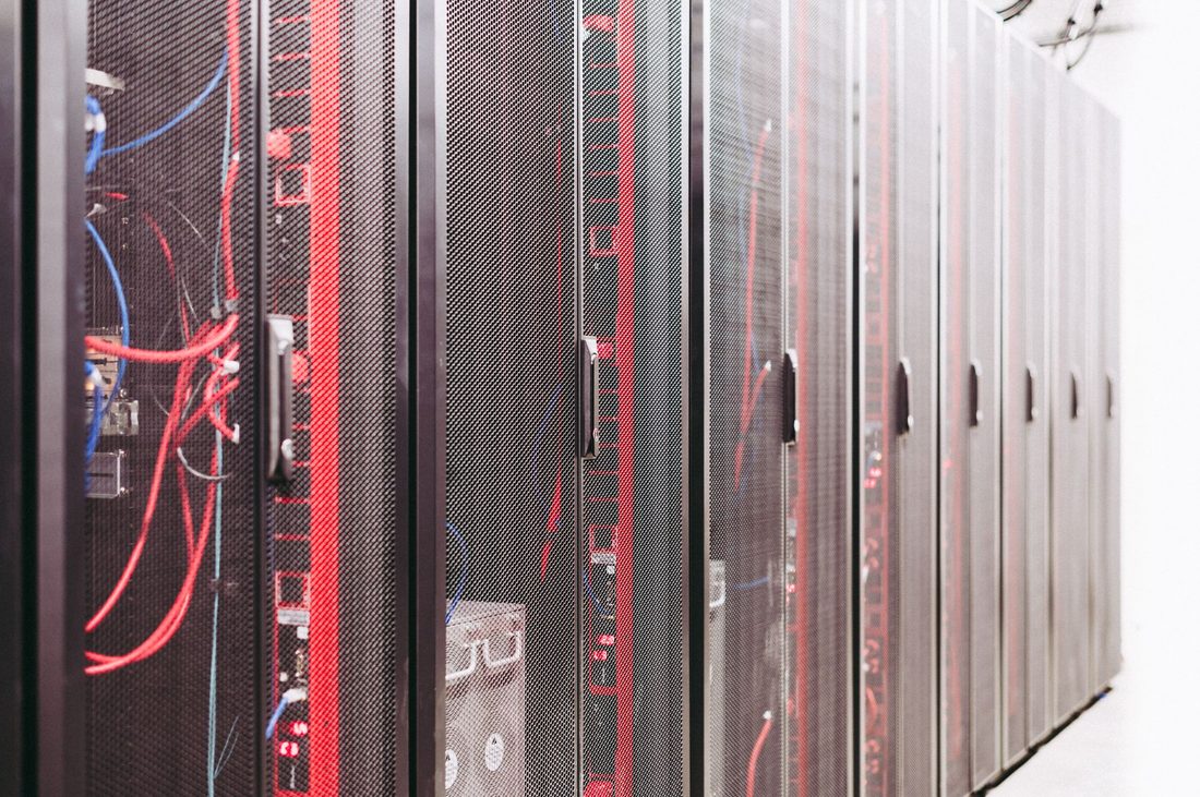 Row of server racks with managed red patch cables in a data centre